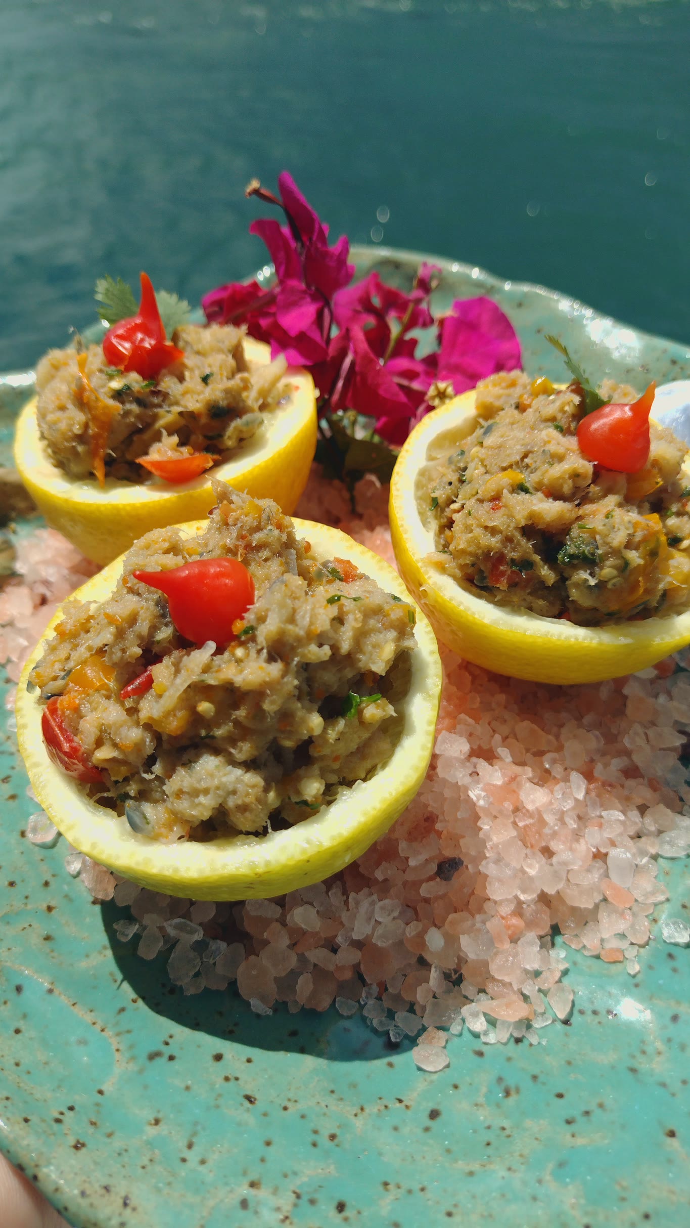 Limones rellenos sobre sal gruesa, en plato de cerámica turquesa