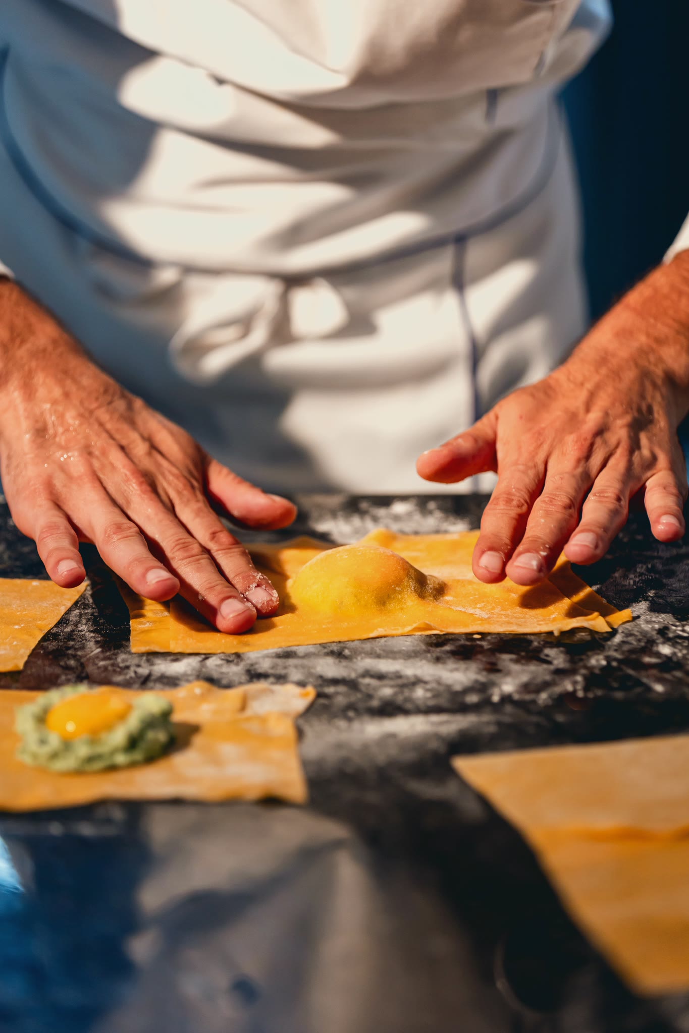 Hands closing the fresh pasta over the filling