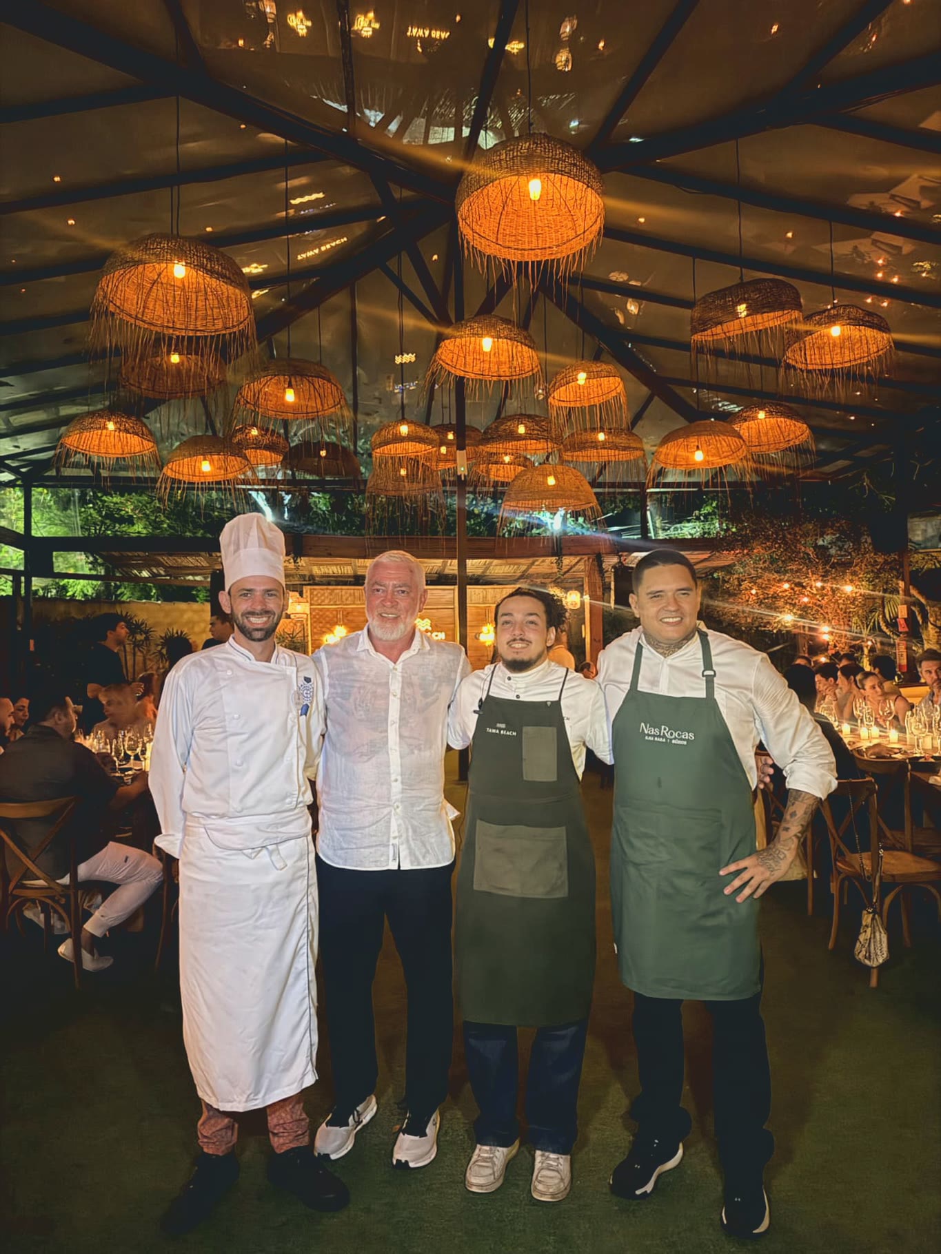 Chef Vitor Jover ao lado de Alex Atala e de dois chefs de avental, no salão do jantar