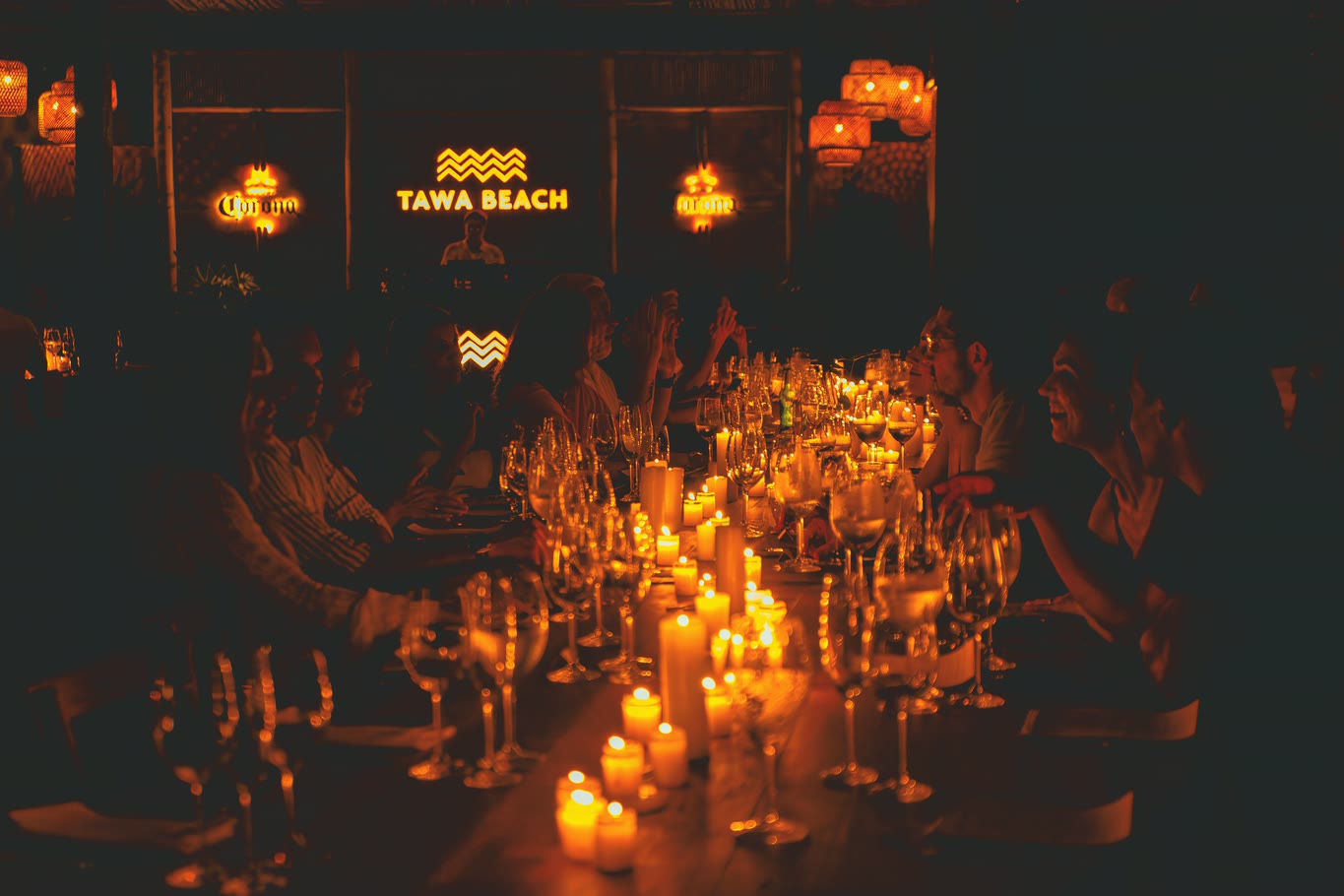 Mesa à luz de velas diante do letreiro TAWA BEACH