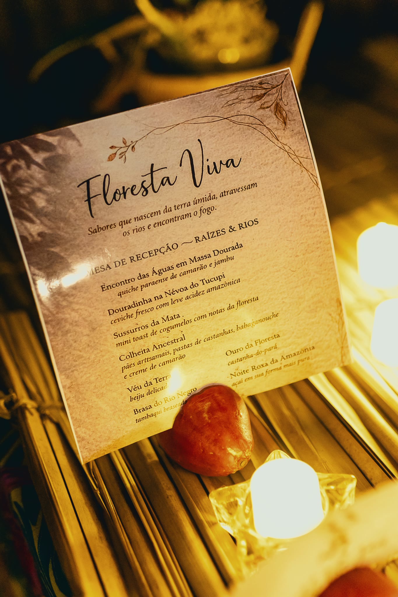 The printed Floresta Viva menu card, propped up by candlelight