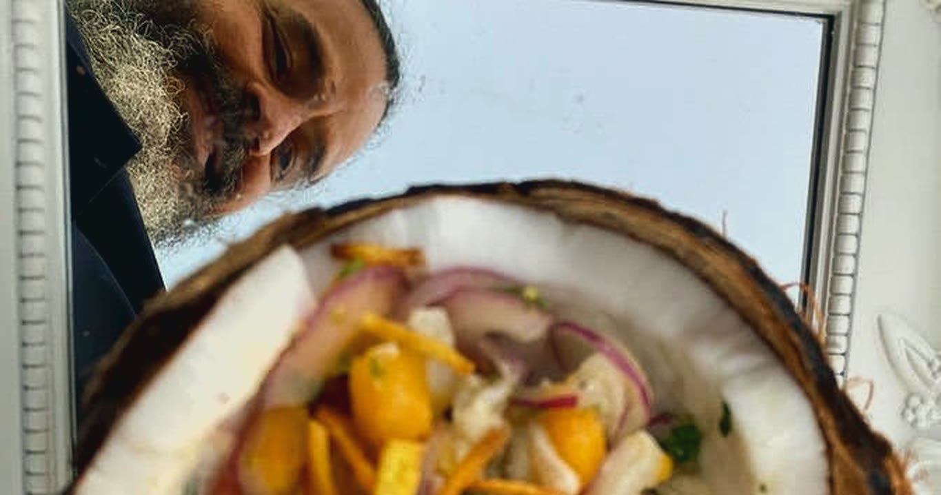 Ceviche en coco sobre la base espejada, que refleja el cielo y el rostro de Bruno