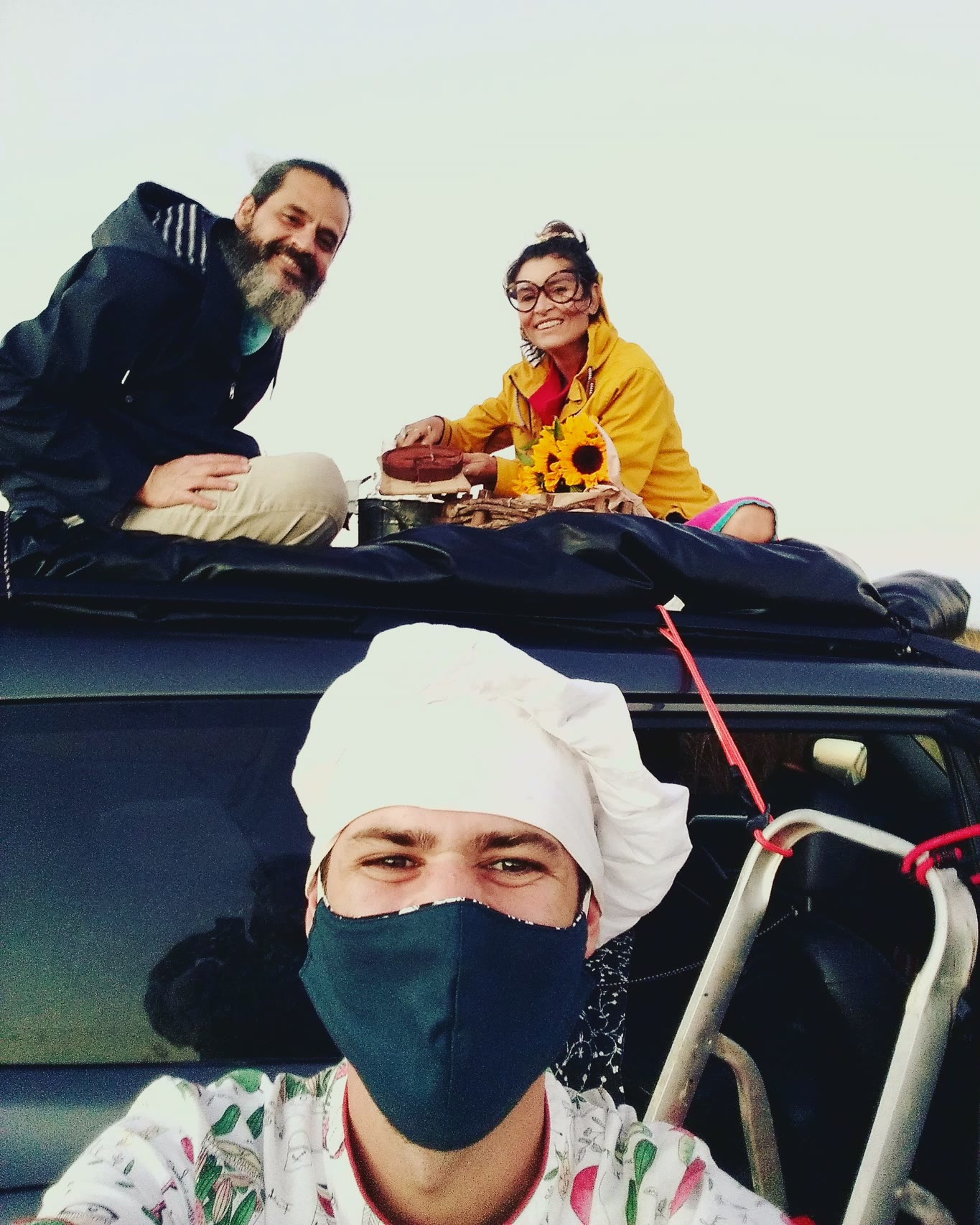Selfie del chef Vitor Jover, con mascarilla, con Bruno y Dominique sentados en el techo de la camioneta