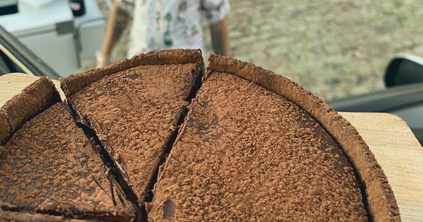 Torta de chocolate cortada en porciones, espolvoreada con cacao